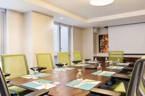 A meeting room in the Hilton Garden Inn Midtown East, with long wooden table and space for ten attendees.