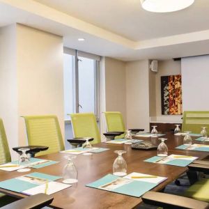 A meeting room in the Hilton Garden Inn Midtown East, with long wooden table and space for ten attendees.