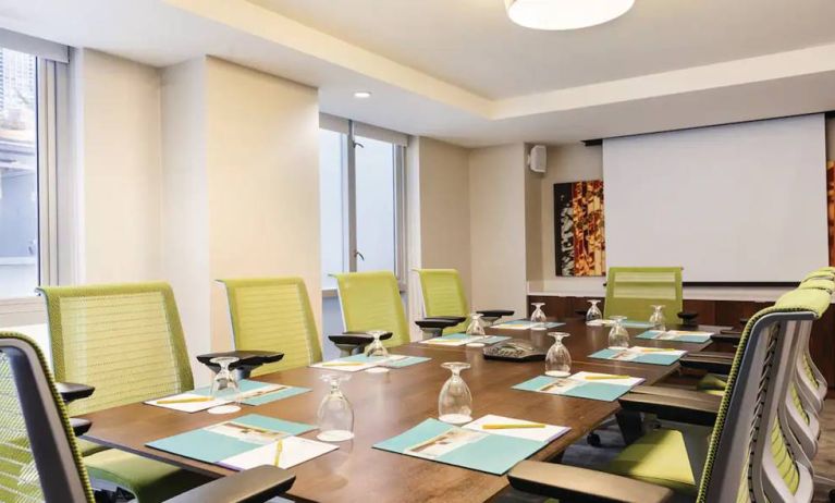 A meeting room in the Hilton Garden Inn Midtown East, with long wooden table and space for ten attendees.