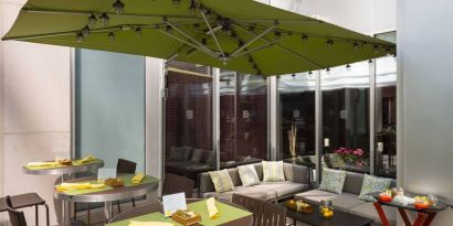 The hotel’s outdoor patio seating area, with mix of tables and chairs, and sofa seating.