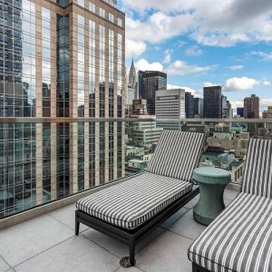 Panoramic city views from a guest room balcony in The Draper, Ascend Hotel Collection, with a pair of loungers.