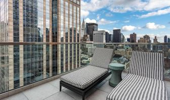 Panoramic city views from a guest room balcony in The Draper, Ascend Hotel Collection, with a pair of loungers.