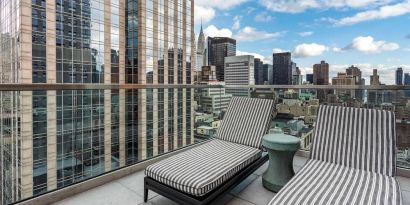 Panoramic city views from a guest room balcony in The Draper, Ascend Hotel Collection, with a pair of loungers.