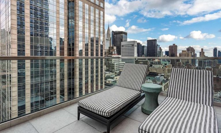 Panoramic city views from a guest room balcony in The Draper, Ascend Hotel Collection, with a pair of loungers.