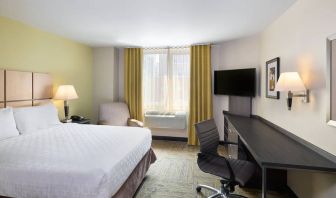 Double bed guest room in the Candlewood Suites Times Square, with workspace nearby and large window.