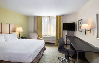 Double bed guest room in the Candlewood Suites Times Square, with workspace nearby and large window.