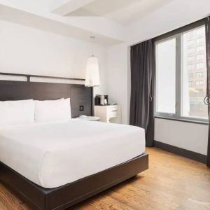 Guest room in the Hyatt Union Square New York, with large bed, window, and workspace.