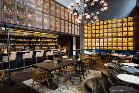 The bar and lounge of Hyatt Union Square New York, with hard floor, bar stools, and range of table sizes.