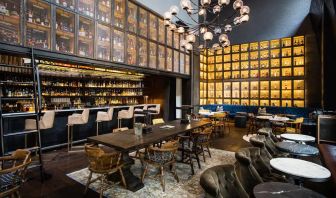 The bar and lounge of Hyatt Union Square New York, with hard floor, bar stools, and range of table sizes.