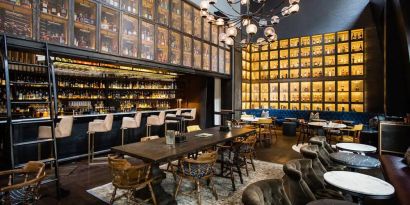 The bar and lounge of Hyatt Union Square New York, with hard floor, bar stools, and range of table sizes.