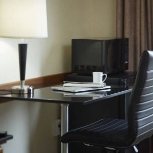 An in-room workspace at the Comfort Inn Belleville, including desk, chair, and lamp.