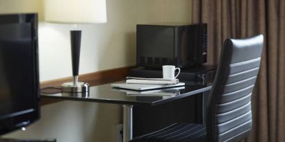 An in-room workspace at the Comfort Inn Belleville, including desk, chair, and lamp.