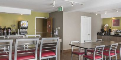 The hotel breakfast area has tall and standard chairs, and a wide range of breakfast fare.