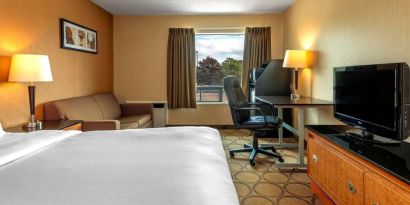 Double bed guest room in Comfort Inn Sault Ste. Marie, including a workspace desk and chair.