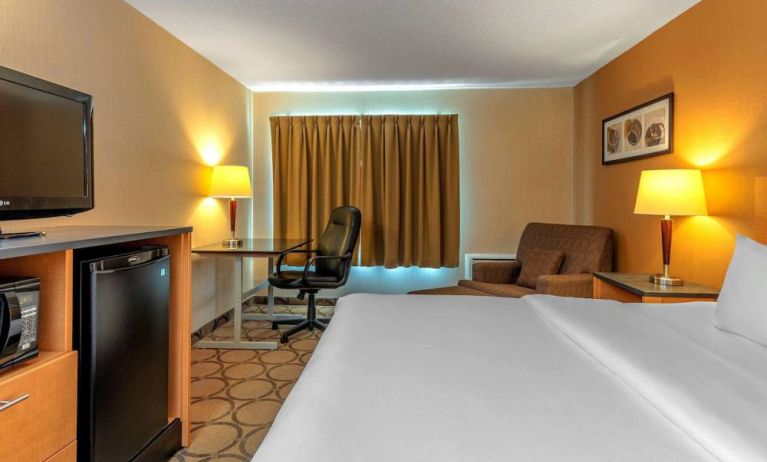 Comfort Inn Sault Ste. Marie guest room featuring large double bed, TV, and armchair.