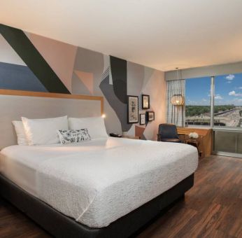 Guest room in The Beeman Hotel, with workspace desk and chair, plus large double bed.