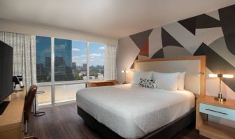 Double bed guest room in The Beeman Hotel, featuring large bed, and city view through the window.