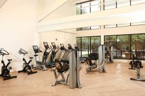 The hotel fitness center is brightly lit and has a broad selection of exercise machines.