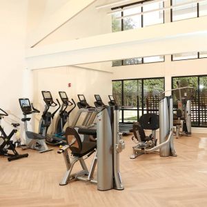 The hotel fitness center is brightly lit and has a broad selection of exercise machines.