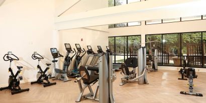 The hotel fitness center is brightly lit and has a broad selection of exercise machines.