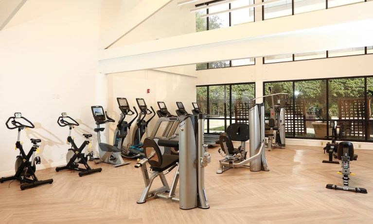 The hotel fitness center is brightly lit and has a broad selection of exercise machines.