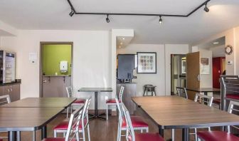 The hotel breakfast area has a hard floor and tables for two to four diners.