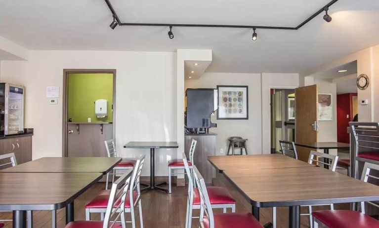 The hotel breakfast area has a hard floor and tables for two to four diners.