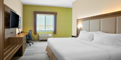 Comfortable king bedroom with TV and business desk at Holiday Inn Express & Suites Ontario.