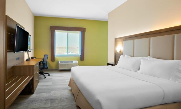 Comfortable king bedroom with TV and business desk at Holiday Inn Express & Suites Ontario.