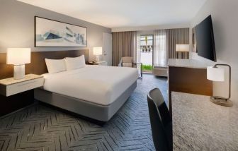 Spacious king suite with TV and business desk at Delta Hotels Orlando Celebration.