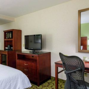 Hilton Garden Inn Queens/JFK Airport guest room with large bed and a workspace desk and chair.