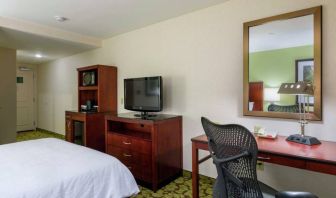 Hilton Garden Inn Queens/JFK Airport guest room with large bed and a workspace desk and chair.