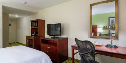 Hilton Garden Inn Queens/JFK Airport guest room with large bed and a workspace desk and chair.