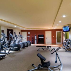 The hotel fitness center has racks of weights and assorted exercise machines.