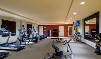 The hotel fitness center has racks of weights and assorted exercise machines.