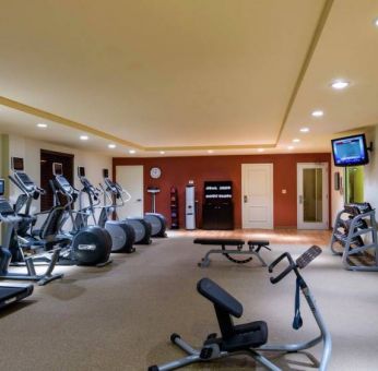 The hotel fitness center has racks of weights and assorted exercise machines.