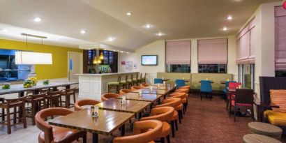 The on-site restaurant of Hilton Garden Inn Queens/JFK Airport has a bar and mostly small table seating.