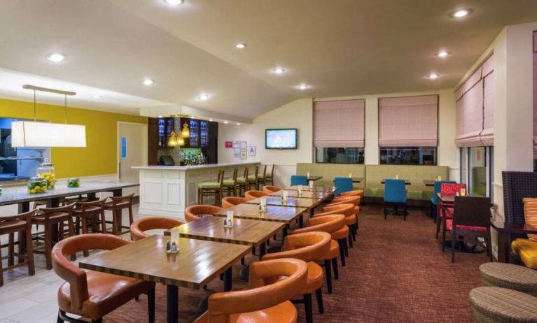 The on-site restaurant of Hilton Garden Inn Queens/JFK Airport has a bar and mostly small table seating.