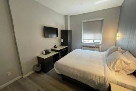 King Hotel Brooklyn guest room, featuring double bed and window with blind.