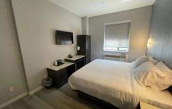 King Hotel Brooklyn guest room, featuring double bed and window with blind.