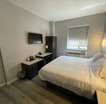 King Hotel Brooklyn guest room, featuring double bed and window with blind.