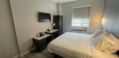 King Hotel Brooklyn guest room, featuring double bed and window with blind.