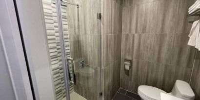 Ensuite bathroom facilities at King Hotel Brooklyn, including lavatory, shower, and sink.