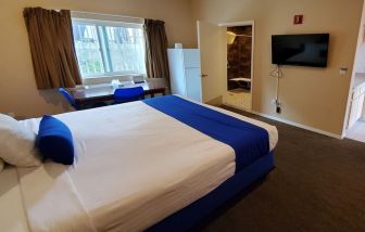 Spacious king bedroom with TV and work station at Colony Inn Universal Studios.