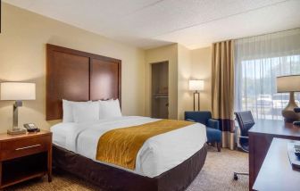 Delux king bed with TV and business desk at Comfort Inn Atlanta Airport.
