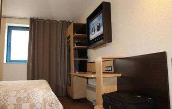 Delux king bed with TV and business desk at Eurohotel Airport Orly Rungis.