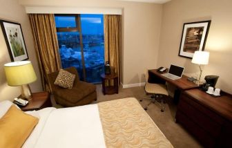 Delux king bed with business desk at Pacific Gateway Hotel Vancouver Airport.