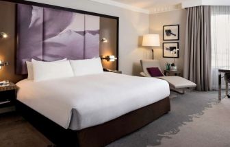 Delux king bed with TV and business desk at Pullman Miami Airport.