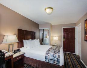 Delux king bed with TV and business desk at Ramada by Wyndham Vancouver Downtown.