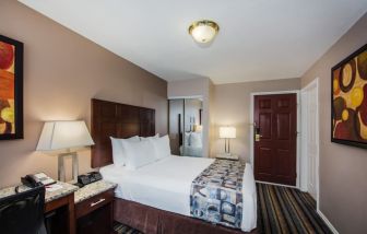 Delux king bed with TV and business desk at Ramada by Wyndham Vancouver Downtown.